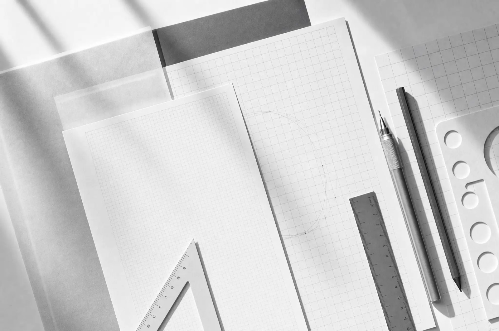 Sheets of grid paper and drafting tools on a desk